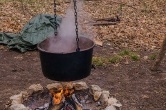 A native pot boiling sap into syrup over a wood fire.