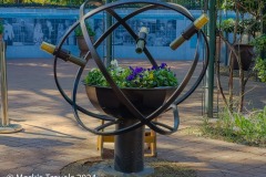 An ornamental sculpture with a grouping of flowers.  There are three kaleidoscopes that can be used to the flowers in the Tuscon Botanical Gardens