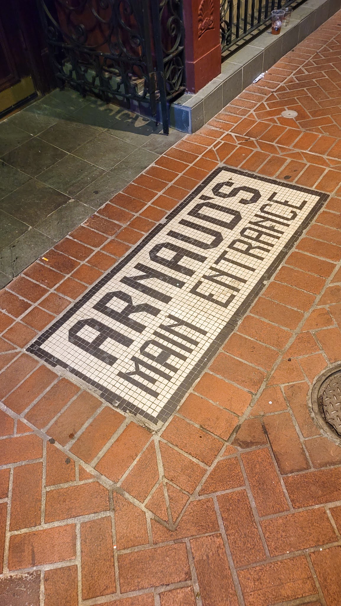 In the sidewalk is a tile mosaic spelling out Arnaud's Main Entrance